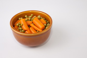 Bowl of boiled carrots and green peas
