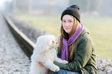 Girl with dog playing on the railroad