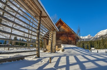 Fototapeta na wymiar Hayrack and barn in the Alpine meadow in Winter