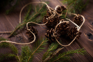 Holiday decoration spruce with cones on wooden background