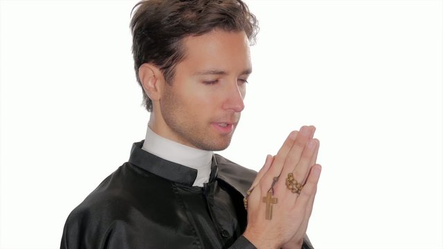 young catholic priest saying a prayer