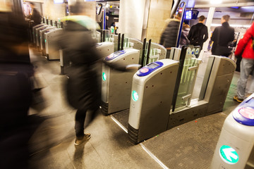 Menschen in Bewegungsunschärfe an einer Bahnsteigsperre