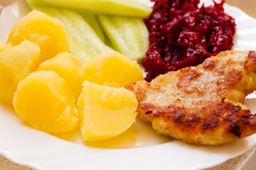 Dinner meal. Fried chicken potatos salad on plate.