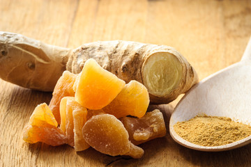 Candied fresh and ground ginger on rustic table