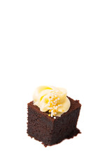 Bite sized chocolate cake with cream cheese toppings over white 