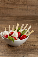 Caprese salad on a sticks with mozzarella, tomatoes and basil