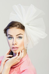 Gorgeous young woman with makeup and tulle bow