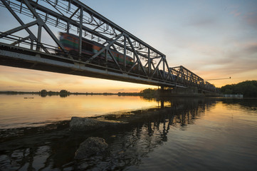 Pociąg wjeżdżający na stary żelazny most kolejowy - obrazy, fototapety, plakaty