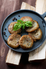 Close-up of a frying pan with potato pancakes, studio shot