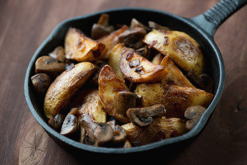 Close-up of a pan with roasted unpeeled potato and mushrooms