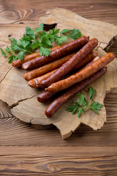 Stack of smoke-dried sausages with fresh parsley, studio shot