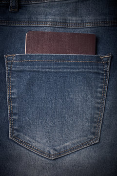 The pocket of jeans with document. Cloth background. Toned