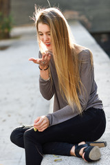 Happy blonde girl smiling in urban background