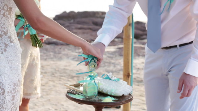 Bride with the groom pour into a pot multicolored sand