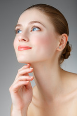 Beautiful Woman Touching her neck. Smiling girl with blue eyes.