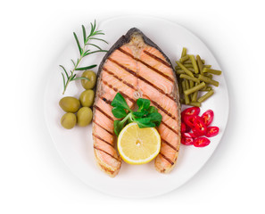 White plate of salmon steak with vegetables.