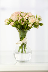 Beautiful bouquet of flowers in vase on window background