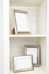Photo frames on shelf on brick wall background