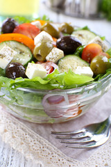 Greek salad in glass dish with fork