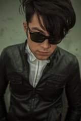 fashion man wearing sunglasses looking at the camera.