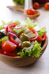 Greek salad in bow on wooden table background