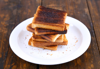 Fototapeta na wymiar Burnt toast bread on plate, on wooden table background
