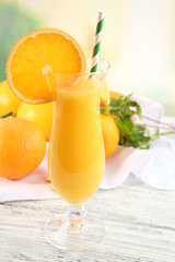 Glass of orange juice with straw and slices