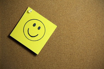Smile symbol drawn on yellow post it note. Concept of Happiness