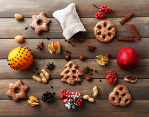 Cookies with fruits and spices on wooden background