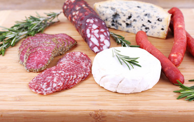 Smoked sausages with cheese, olives and sprigs of rosemary