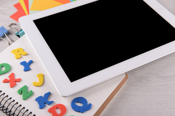 Tablet PC with notebook and colorful letters