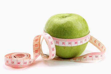 A green apple and a measuring tape
