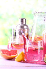 Pink lemonade in glasses and pitcher on table close-up