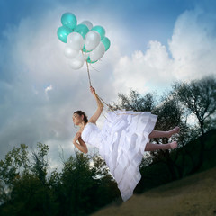 Beautiful bride in a wedding dress flying on balloons