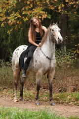 Beautiful girl riding a horse without bridle or saddle