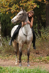 Beautiful girl riding a horse without bridle or saddle