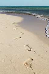 footprints on white sand beach