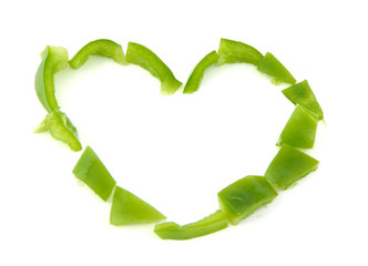 Heart shape formed with chopped green pepper on white background