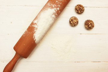 Cookies on the white wooden table with rolling pin and flour