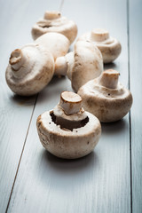 White button mushrooms on a wooden blue table