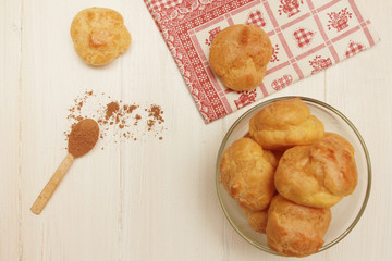 Pastry puffs  with wooden spoon of cacao powder