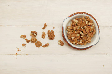 Walnuts in a bowl on the white wooden table
