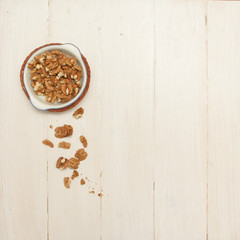 Walnuts in a bowl on the white wooden table