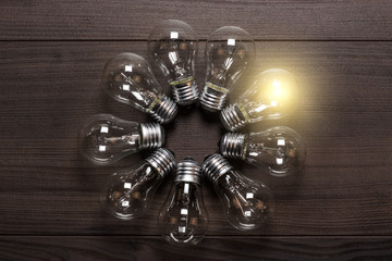 glowing bulb on wooden background uniqueness concept