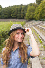 Cute young girl in a hat in a historic park. Tourism.
