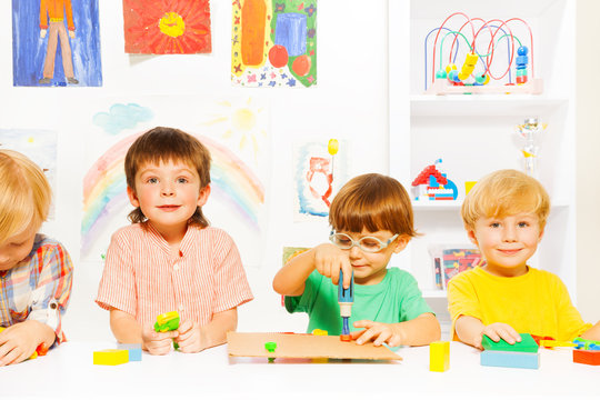 Group of boys in classroom with toy work tools