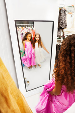 Two happy girls look into the mirror