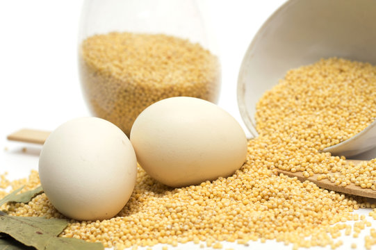 Millet in the bank, a wooden spoon, eggs and bay leaf. Photo.