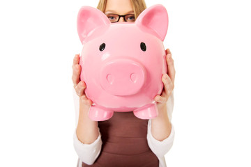 Young woman holding piggybank