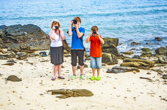 Family takes a photo at the rocky beach